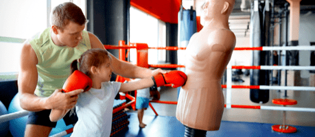 martial arts instructor teaching young girl how to punch